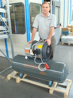 Jay Hedges standing behind a horizontal air receiver tank on a pallet.
